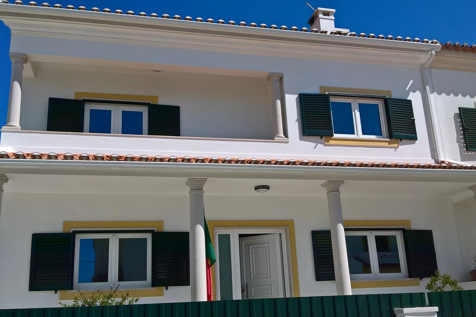 Moradia com janelas e portas brancas em PVC e portadas exteriores
